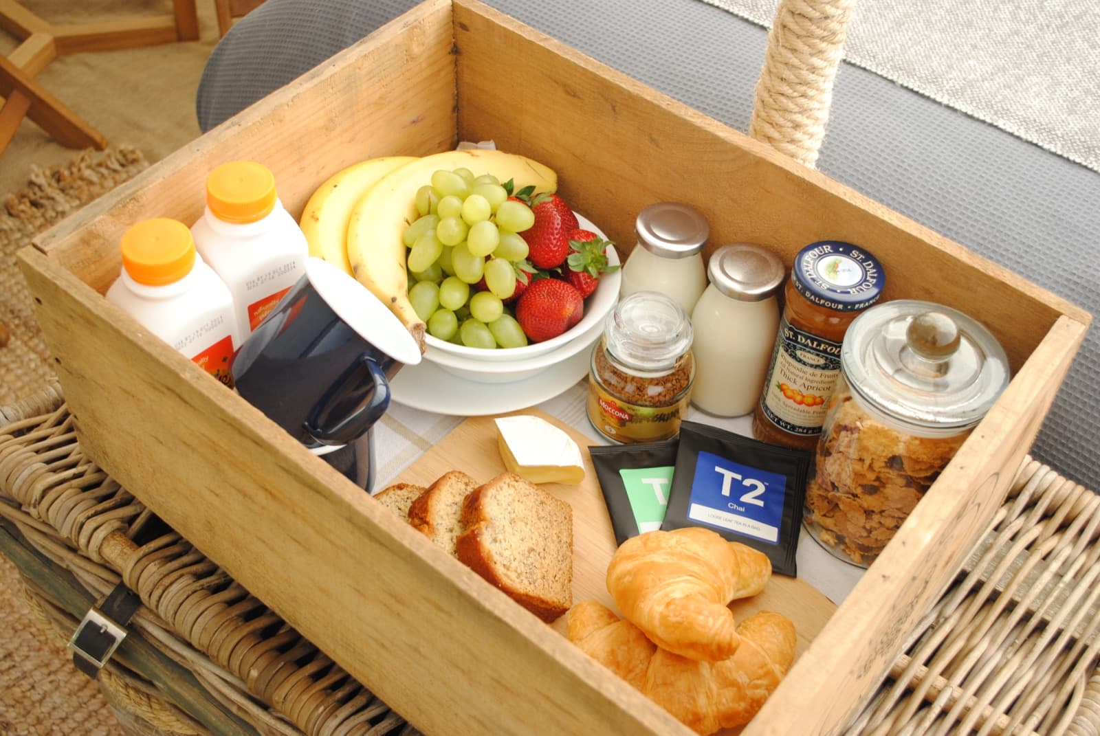 The Brekkie Box: a timber crate of pastries, grapes and strawberries, cereal, yoghurt, juice, T2 tea and Moccona coffee