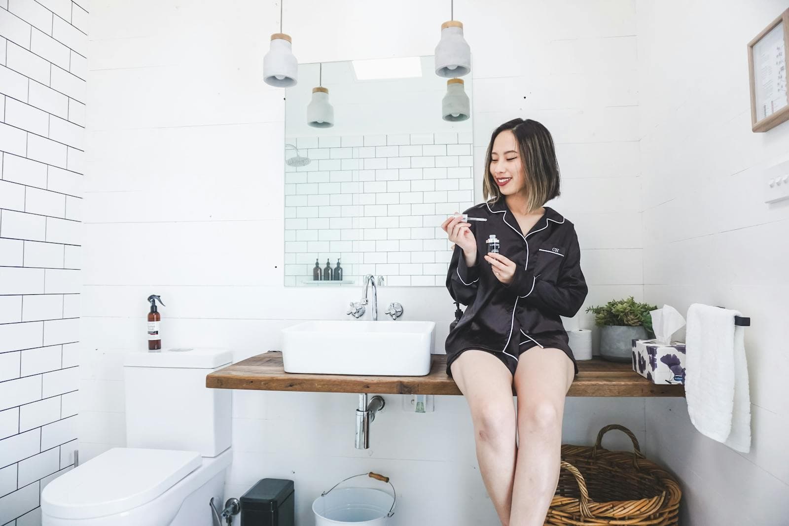 Inside the shared bathroom block: white tiles, a timber bench and a basin